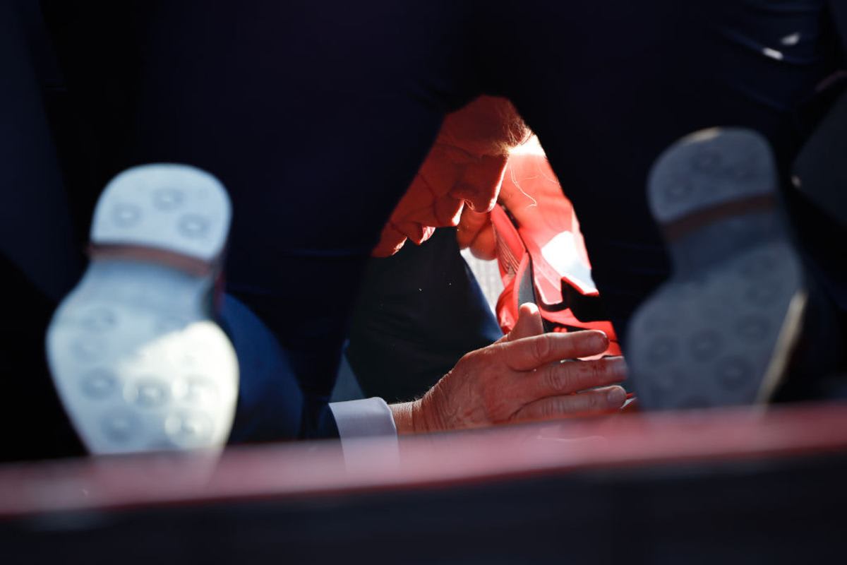 Secret Service tend to republican presidential candidate former President Donald Trump onstage after he was grazed by a bullet at a rally on July 13, 2024 in Butler, Pennsylvania. Butler county district attorney Richard Goldinger said the shooter is dead after injuring former President Trump, killing one audience member and injuring another in the shooting. (Photo by Anna Moneymaker/Getty Images)